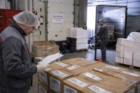 Сотрудник склада проверяет документы и маркировку партии мясной продукции перед отгрузкой в собственную розничную сеть